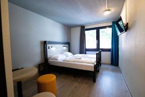 鹿特丹a&o Rotterdam City的一间卧室配有床和蓝色窗帘的窗户