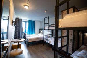 鹿特丹a&o Rotterdam City的客房设有三张双层床和一张桌子。