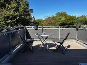 杜伊斯堡A&V Apartments Wunderschöne Rheinblick Wohnung zum entspannen的阳台配有一张桌子和两把椅子