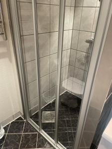 莫吕Måløy City Center - Château Kvalheim的浴室里设有玻璃门淋浴
