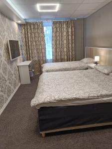 纳尔瓦APARTHOTEL的酒店客房设有两张床和电视。