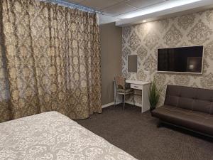 纳尔瓦APARTHOTEL的酒店客房配有一张床、一张沙发和一张书桌。