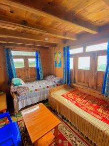 PanaotiMount Mahabharat Homestay的客房设有两张床、一张桌子和窗户。