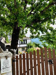 KríkellonΤΟ ΑΡΧΟΝΤΙΚΟ的房屋前有树的木栅栏