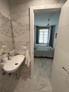 塞维利亚斑点中央旅馆的一间带水槽的白色浴室和一间卧室