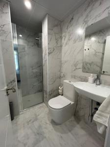 塞维利亚斑点中央旅馆的浴室配有卫生间、盥洗盆和淋浴。