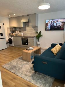 KentDartford Luxurious House with Parking - Netflix - Wi-Fi的客厅配有蓝色的沙发和桌子