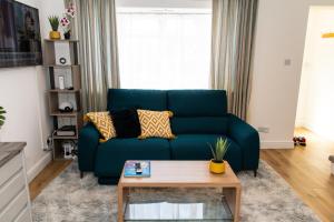 KentDartford Luxurious House with Parking - Netflix - Wi-Fi的客厅配有蓝色的沙发和茶几