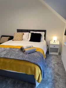 KentDartford Luxurious House with Parking - Netflix - Wi-Fi的一间卧室配有一张带黄色毯子的大床