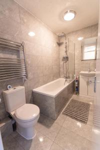 KentDartford Luxurious House with Parking - Netflix - Wi-Fi的浴室配有卫生间、浴缸和水槽。