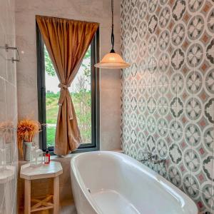 Pong TalongTubtao Sleepy Hill的带浴缸的浴室和窗户