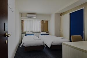 大阪Folio Sakura Shinsaibashi Osaka by Banyan Group的酒店客房带两张床和厨房