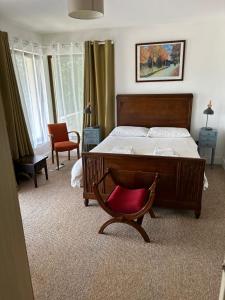 基拉尼Modern 4 Bedroom House Ring of Kerry -Killarney的一间卧室配有一张床和一张红色椅子