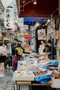 大阪Folio Sakura Shinsaibashi Osaka by Banyan Group的市场,人们围坐在餐桌旁吃着食物