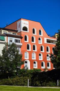 博尔扎诺La Briosa的一座大型的橙色建筑,前面有树木