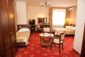 华沙阿卡迪亚皇家酒店 的酒店客房带两张床和一张桌子以及椅子。