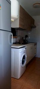 马塔拉斯卡尼亚斯Caracola Beach的厨房配有洗衣机和冰箱。