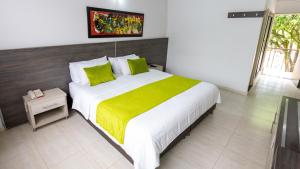 布卡拉曼加Hotel San Juan Internacional的一间卧室配有一张带黄色毯子的大床