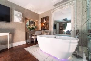 伦敦卡玛桑顿SOHO酒店的一间位于客房内的带大型白色浴缸的浴室