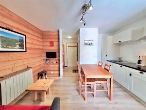 莱德萨阿尔卑斯Boost Your Immo Arc En Ciel C Les Deux Alpes 757的一间厨房和带木墙的用餐室