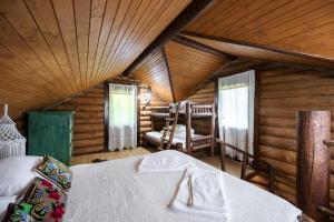 下维谢乌乡Cabana din Revier的小木屋内的卧室,配有一张床和椅子