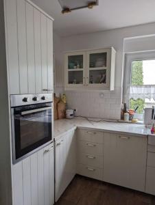 马克兰斯泰特Haus in der Nähe vom See的白色的厨房配有白色橱柜和烤箱