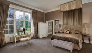比索普顿三月堂高尔夫Spa酒店的一间卧室配有一张床、一把椅子和窗户。