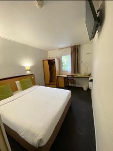 勒布朗-梅尼尔勒布朗-梅尼尔基里亚德酒店的酒店客房设有一张大床和一张书桌。