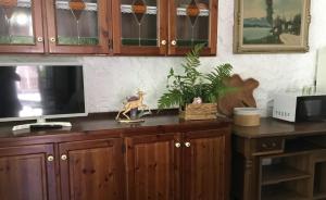 CittiglioMULINO DELLA VALLE的一个带木制橱柜的厨房和一台台面上的电视