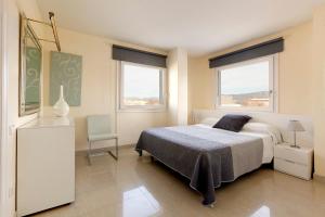 艾姆布里亚布拉瓦茂瑞西公园酒店的一间卧室配有一张床和一把椅子,还有两个窗户