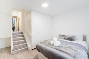 伦敦Large Studio Apartment 30 mins to Oxford Street (B)的一间带大床和楼梯的卧室