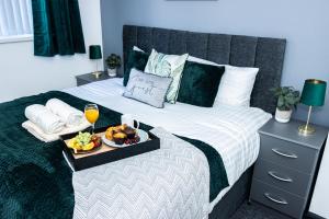达德利Luxurious 3-Bed House in Dudley - DY1的一张床上放着食物和饮料的托盘