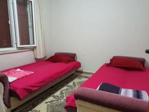 库萨达斯A Vacation House 60 m. To Seashore的配有粉红色床单和窗户的客房内的两张床