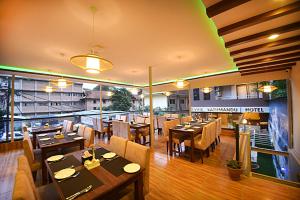 加德满都Divine Kathmandu Hotel的一间设有木桌和椅子的餐厅