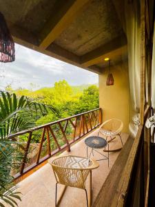 埃尔扎伊诺Villa Tayrona的设有一个配有两张桌子和椅子的阳台,享有美景。