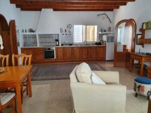 埃尔帕索Villa Jardines la Quinta的一间带白色沙发的客厅和一间厨房