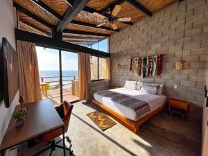 维加伊托DIEM Vichayito Beachfront Eco-Luxury的一间卧室配有一张床、一张书桌和一个窗户。