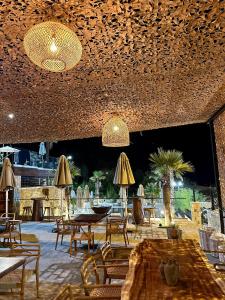 地拉那Bianca Hotel & Villa的一间带桌椅和遮阳伞的餐厅