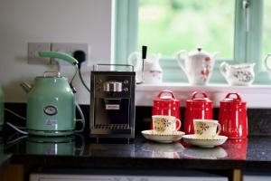 WiggintonTring Grange Cottage的厨房柜台配有咖啡壶和茶杯