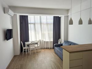 库塔伊西Brand new apartment in Kutaisi的客厅配有蓝色的沙发和桌子