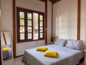 迈里波朗Cantareira - Deck House的一间卧室配有一张带黄色枕头的床。