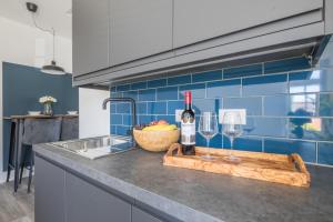 WolvertonRadcliffe Studios的厨房柜台,配有两杯酒和切断板