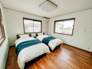 横须贺市シテコベハウス的带2扇窗户的客房内的2张床