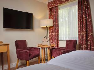 贝德福德The Kingfisher的酒店客房配有一张床、两把椅子和一台电视