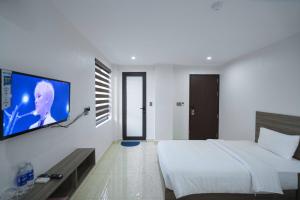 下龙湾AURORA BÃI CHÁY HẠ LONG的一间卧室配有一张床,墙上配有电视