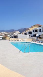 圣地亚哥港Oceanfront Beach Apartment la Arena的一座拥有蓝色海水和白色建筑的游泳池