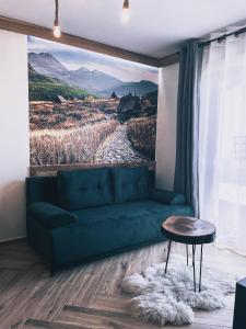 穆扎希赫尔Apartamenty Pod Brzezinami的客厅配有绿色沙发和绘画作品