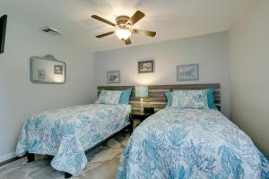 奈安蒂克Coastal Getaway with Porch, 2 Mi to Niantic Beach!的一间卧室配有两张床和吊扇