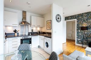 伦敦City-Close 1-Bed Apartment near Tower Hill的厨房配有白色橱柜和桌椅