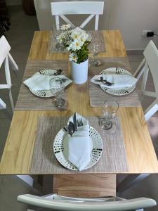 卡拉尔卡Apartamento cacique calarca的一张木桌,上面有盘子和餐巾